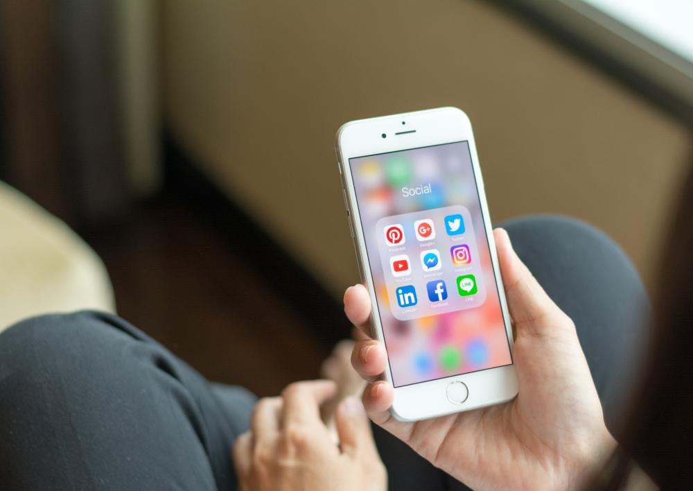 Man met mobiel met social media in de hand
