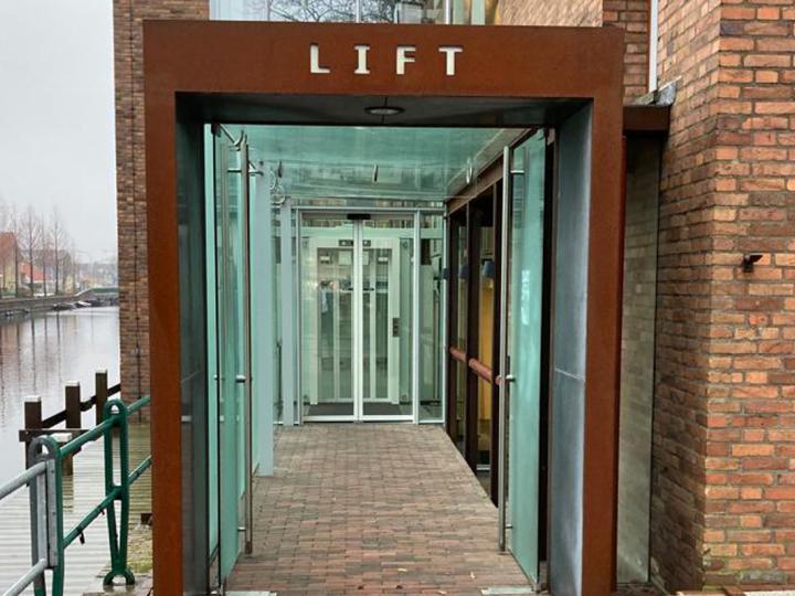 Lift aan linkerzijde van het gebouw