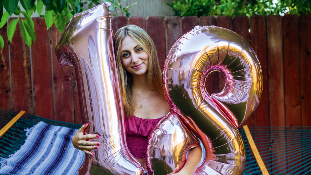 Meisje met ballonnen met cijfers 1 en 8 in de handen